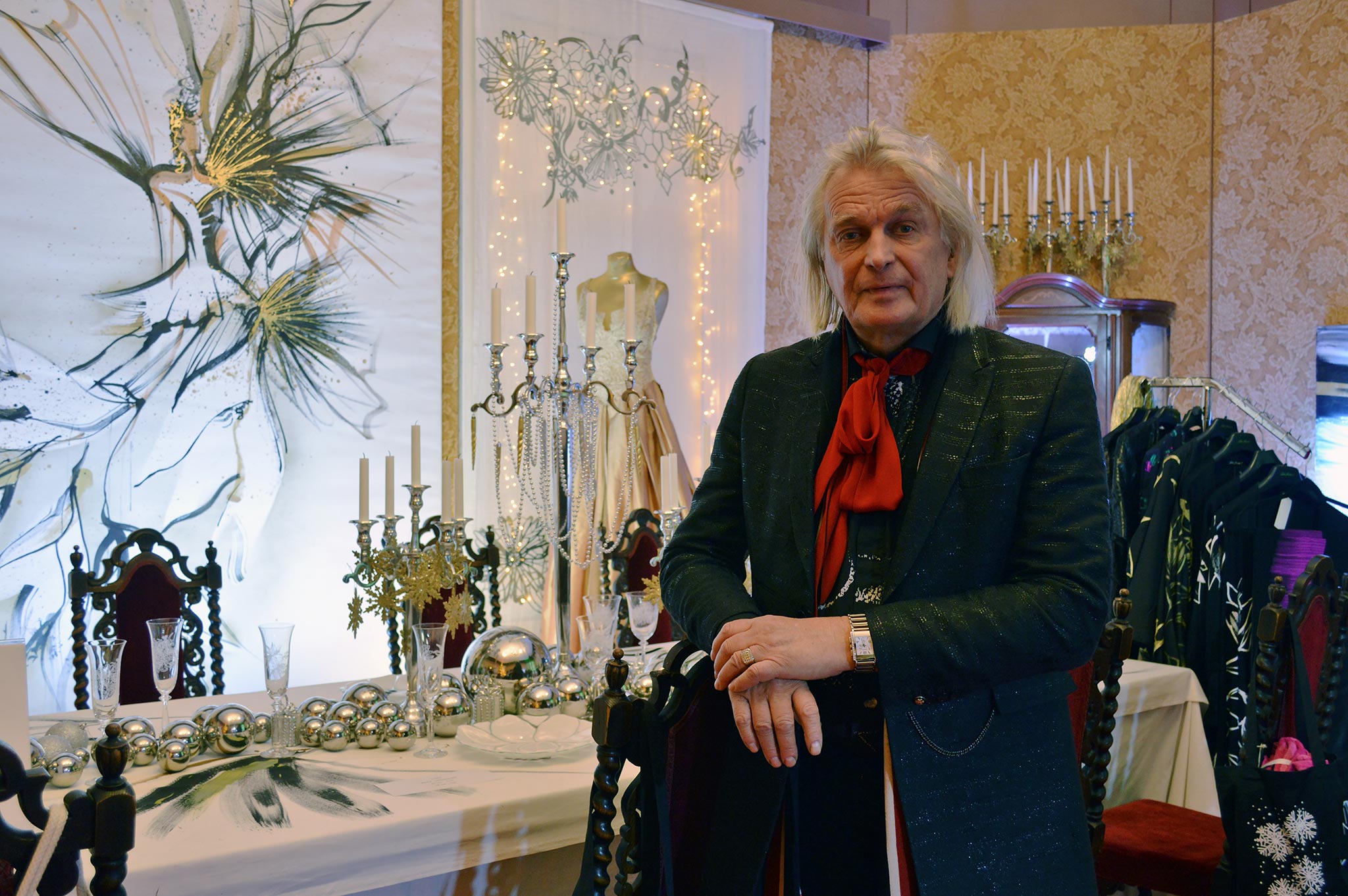 Muotisuunnittelija Jukka Rintala poseeraa ylellisen juhlakattauksensa edessä Aladinin palatsissa. © Elisa Helenius