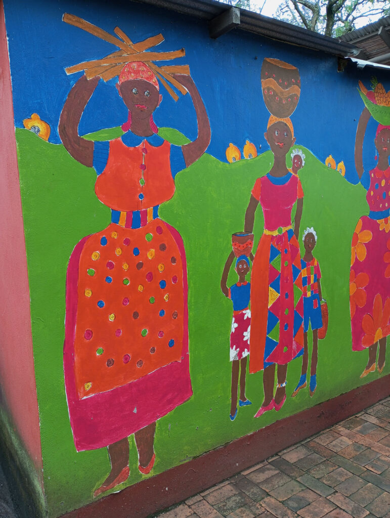 Eswatinilaiset ihmiset ovat hyväntuulisia ja humoristisia. Kuvassa seinämaalaus ihmisistä.